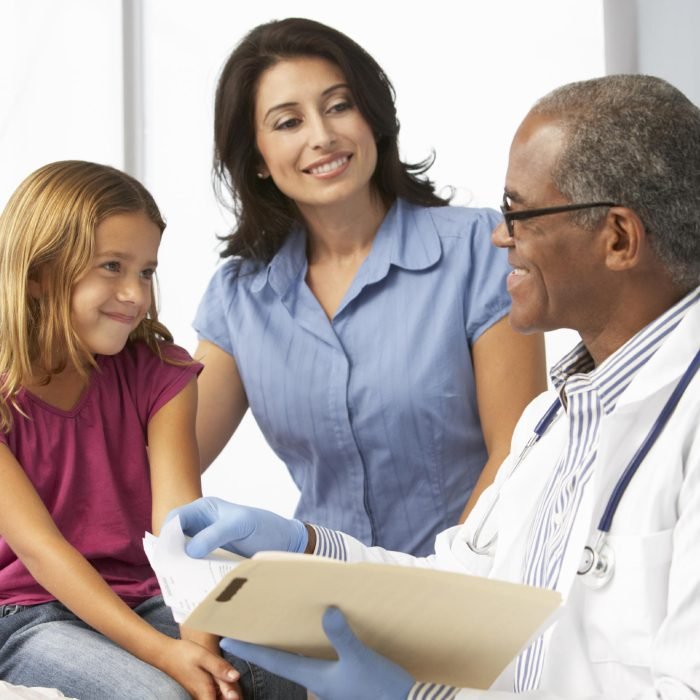 Doctor In Surgery Examining Young Girl